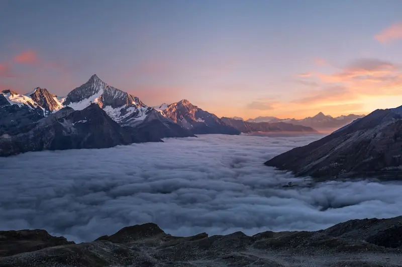 Sunset alpenglow over Mount Moosilauke summit with dramatic cloud sea below
